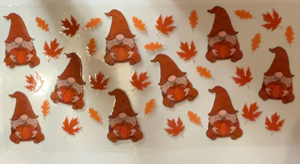 Fall tumbler wrap with orange gnomes holding pumpkins and autumn leaves