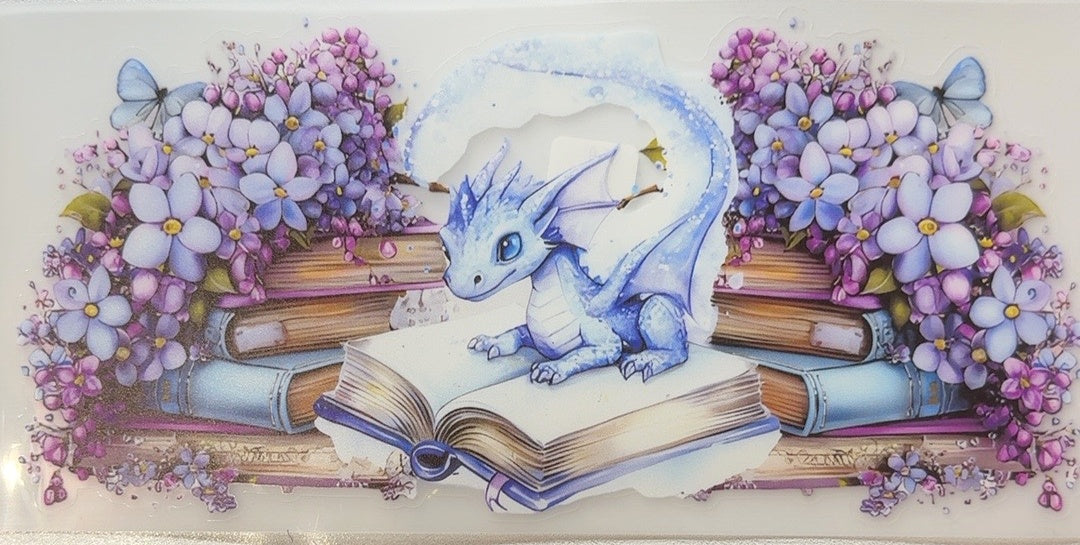Blue dragon on open book with purple flowers fantasy tumbler wrap